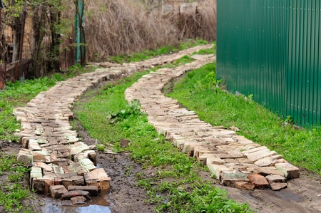 Brick road in green grass country roadの写真素材