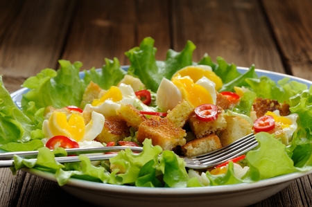 Salad Caesar with eggs, chili pepper and two forks closeup horizontalの写真素材