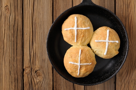 Hot cross buns in cast iron skillet on wooden background with spaceの写真素材