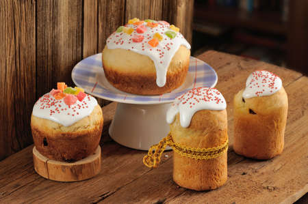 Kulich, Russian easter sweet breads decorated with icing and candied fruits on wooden background...