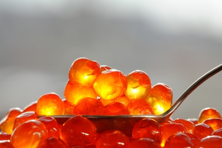 Red caviar in silver spoon close up macro
