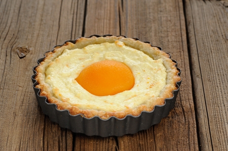 Peach tart with creamy filling on wooden background horizontal closeupの写真素材