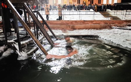 Orel, Russia, January 19, 2018: Epiphany. Young men dipping themselves in ice hole at midnight and...