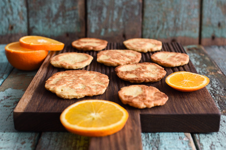 Healthy vegetarian sweets. Homemade cookies with orange on oak board on shabby blue background...