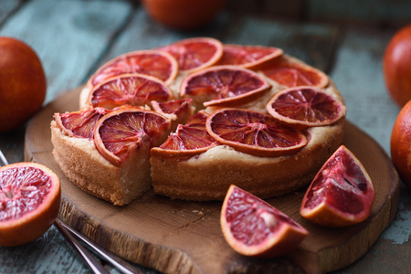 Homemade fruit cake. Blood orange slices on cake served on oak board closeupの写真素材