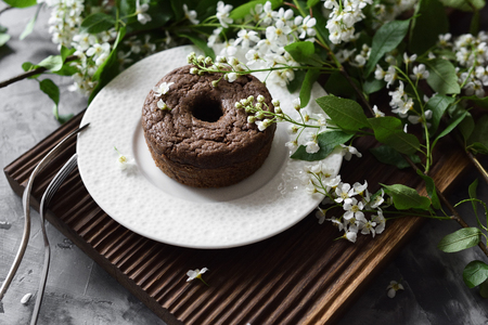 Yummy chocolate cake and white bird cherry blossoms on dark background side viewの写真素材