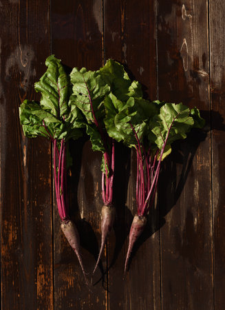 Beetroot with tops on a wet wooden background overhead viewの写真素材