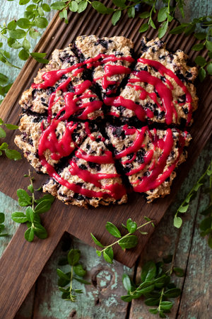 Blueberry cutted scones on oak cutboard with blueberry leaves overhead viewの写真素材