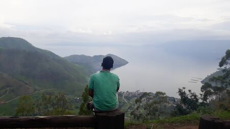 Medan, North Sumatra / Indonesia - November 3, 2018 : A man enjoy Lake Toba in the eveningのeditorial素材