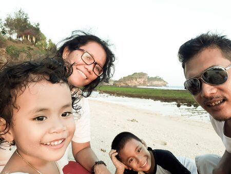Pacitan, East Java / Indonesia - June, 2019 : A family at Watu Karung beach during school holidayのeditorial素材