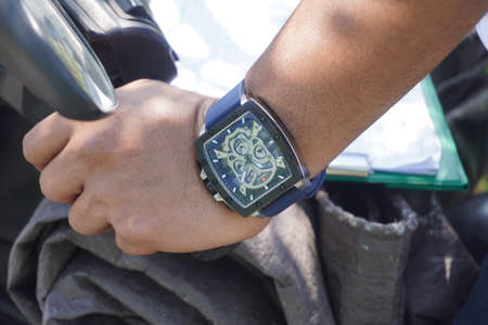 closed up the watch on the left hand holding the motorcycle handlebars