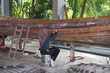 Surabaya, east java, Indonesia - June, 2022 : young woman marine engineering student making a wooden boatのeditorial素材