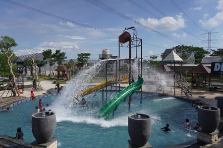 Surabaya, East Java, Indonesia - July, 2022 : spending time when holiday at swimming pool with water splash and kid pool slideのeditorial素材