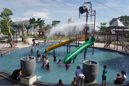 Surabaya, East Java, Indonesia - July, 2022 : spending time when holiday at swimming pool with water splash and kid pool slideのeditorial素材