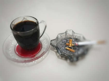 Cigarette and a cup of coffee on a white background.の写真素材