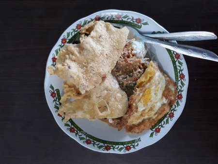 Indonesian traditional food pecel, it is vegetables with peanut sauce garnished by crackers and fried eggの写真素材