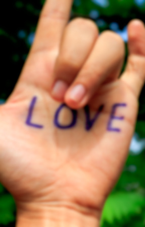 word love on hand and blur tree background.selective focus.の写真素材