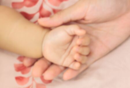 Blur backgroud hand's  mother holding hand' baby.の写真素材