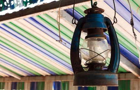 The old lamp hangs on beam colorful blur background.