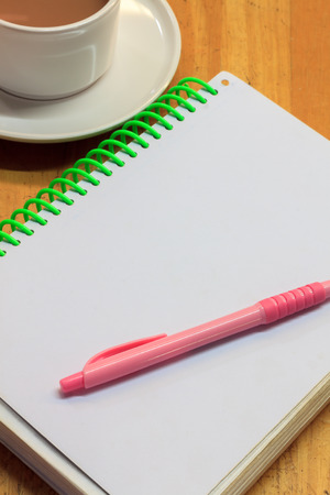 cup of coffee,notebook,pen on wood background.の写真素材