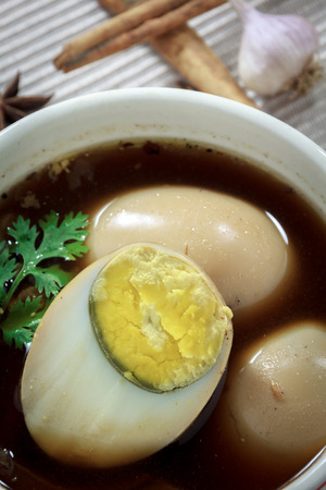 stewed eggs or eggs and pork in brown sauce by Thai food and blur garlic,spices on cloth background.の写真素材