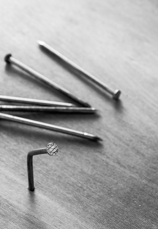 Selective focus unsuccessful to hit the nail.Bent nail on the wood.Blur nails on wood background.の写真素材