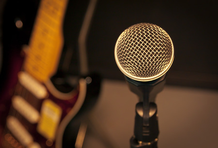 selective focus microphone and blur electric guitar background and flare light.の写真素材