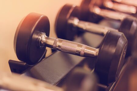 Soft focus the Sport equipment concept dumbbells on rack in fitness gym.
