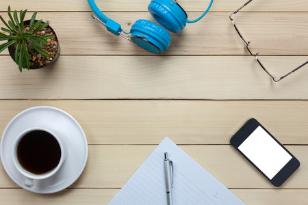 Top view notepaper,headphones,smartphone,pen,coffee ,cactus,eyeglasses on office desk background.の写真素材