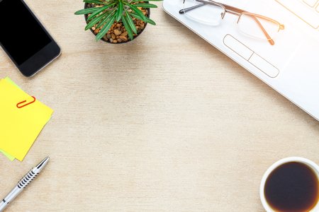 Top view accessories office desk the mobile phone,note paper,coffee,cactus,laptop on wooden office desk background.の写真素材