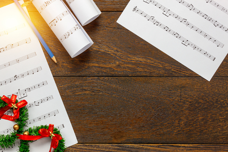 Top view Christmas music note paper  with Christmas decoration on wooden table background.Create this music note paper myself.の写真素材