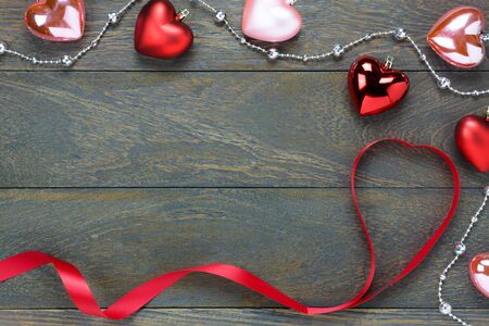 Top view red and pink heart shape also gem clothesline and red heart ribbon on wooden background with copy space.の写真素材