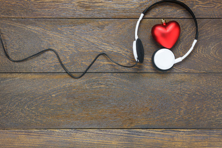 Top view red heart shape listening music with headphones on wooden background and copy space.の写真素材