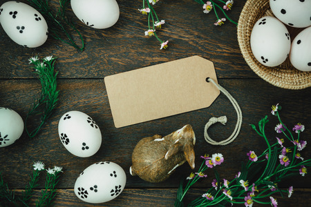 Top view easter background.Happy easter eggs pained on wood basket also beautiful flower and greeting card.Texture rustic wooden with decorations rabbit and copy space.の写真素材
