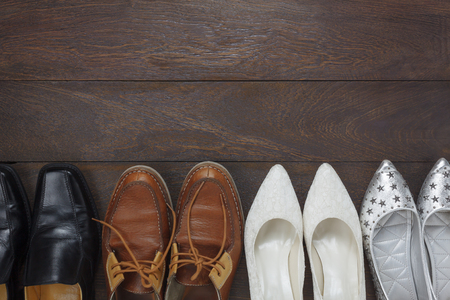Top view  fashionable several design of men and women shoes on wooden floor with copy space.の写真素材