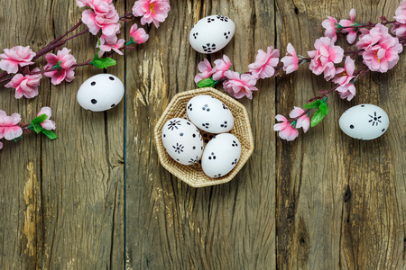 Top view easter background.Happy easter eggs pained on nest also beautiful pink flower.Texture rustic  wooden with decorations and copy space.の写真素材