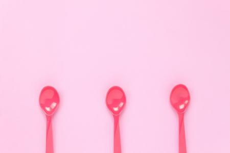 Top view colorful plastic spoon on pink table background with copy space.の写真素材