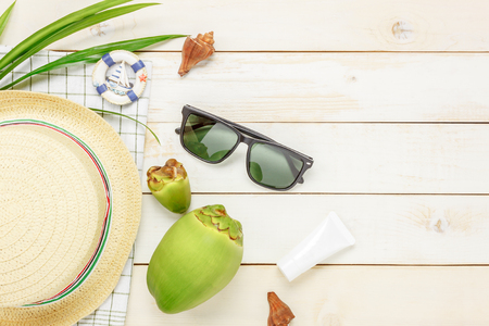Top view essential travel summer items.The sunblock  coconut hat  sunglasses on white  wooden background.の写真素材