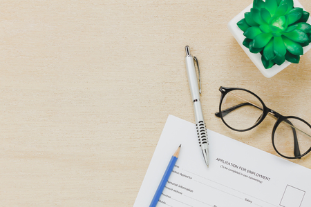Top view business office desk background.The applying for a job form and pen pencil eyeglasses tree on wooden table background with copy space.の写真素材