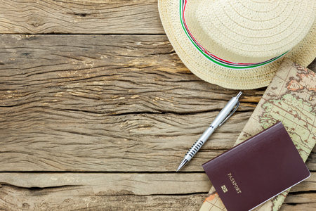 Top view essential items to travel .The map passport pen hat on rustic  wooden background.の写真素材