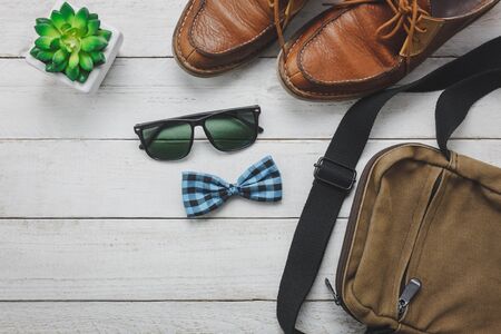 Top view / Flat lay accessoires to travel with man / gentlemen clothing on white wooden background.の写真素材