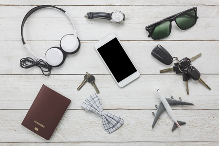 Top view / Flat lay accessoires to travel and technology with man / gentlemen clothing on white wooden tableの写真素材