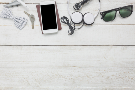 Top view / Flat lay accessoires to travel and technology / music with hipster clothing on white wooden tableの写真素材
