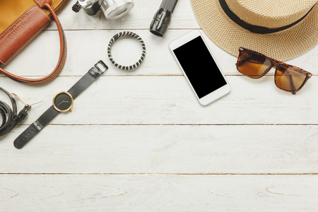 Top view / Flat lay accessoire to travel and technology with woman / lady clothing on white wooden tableの写真素材