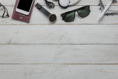 Top view of accessories essential to travel and technology background concept. Several of items for teenage or adult for traveler. Mix variety the objects on modern rustic white wooden office desk.の写真素材