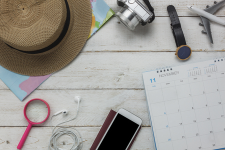 Flat lay of planing travel with technology background concept.Essential several items on the modern white rustic wood office desk.Object prepare for teenage or adult and travel to trip holidays.の写真素材