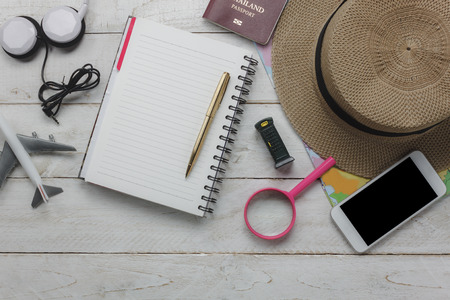 Top view of accessories planning to travel with technology background concept.mix essential item on modern rustic white wooden home office desk.Mix object for traveler to prepare of vacation time.の写真素材