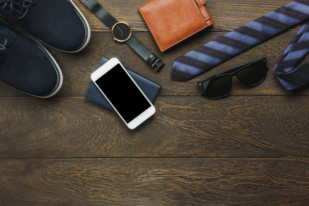 Above view of items to travel with technology background concept.Essential mix variety object on modern rustic brown wood office desk. Accessories  traveler teenage or adult man for vacation.の写真素材