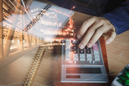 Double exposure finance and offshore oil and gas industrial platform background.Close up Asian hand of finances or accountant calculate expenses with essential accessory on modern table office deskの写真素材