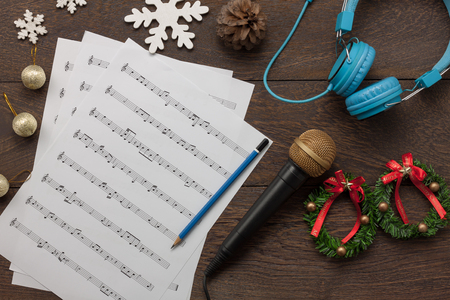 Table top view of music sheet note and accessories Merry Christmas & Happy new year concept.Instrument musical with decoration festive on the modern rustic dark brown wooden at home office desk.の写真素材